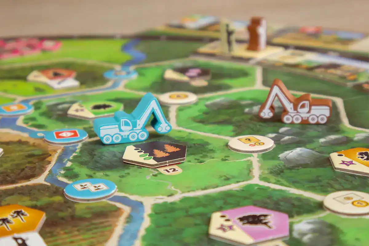 Spielbrett mit Baumaschinen, Karten und Landschaften.